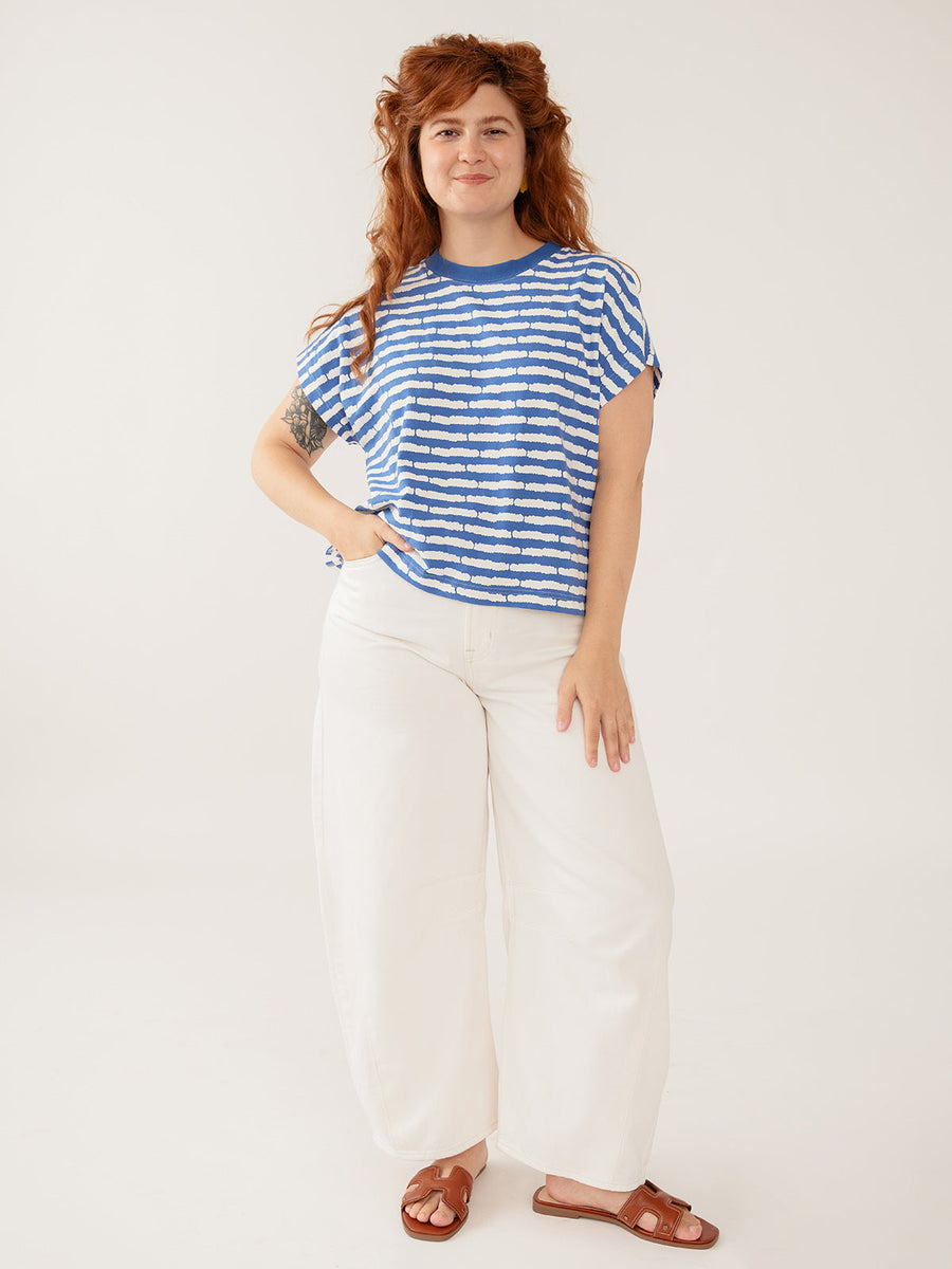 Full-length view of model wearing the Mata Traders Caitlin striped organic cotton tee with white pants and sandals.
