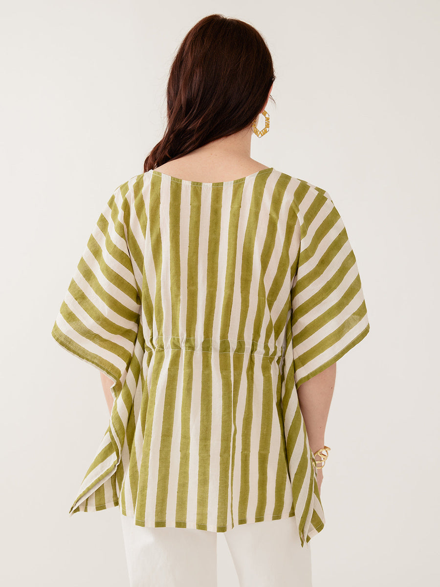 Model wearing the Mata Traders Darcey Kaftan Top in Green Stripe, a handmade, summer-weight olive green and cream vertical striped cotton kaftan shirt with an adjustable drawstring waist and wide, flowing sleeves - Back View