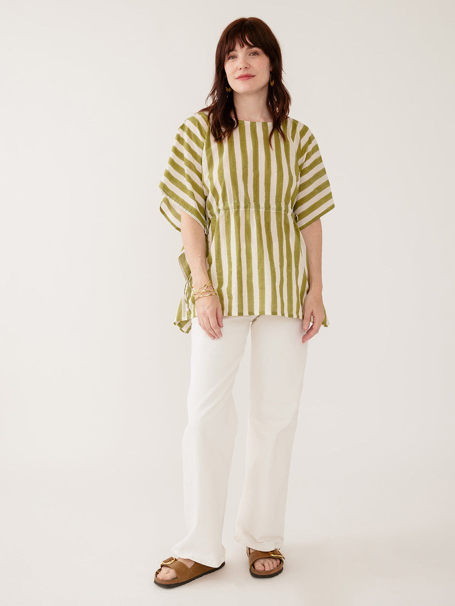 Model wearing the Mata Traders Darcey Kaftan Top in Green Stripe, a handmade, summer-weight olive green and cream vertical striped cotton kaftan shirt with an adjustable drawstring waist and wide, flowing sleeves.