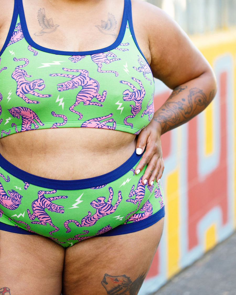 Close-up torso view focusing on the high-rise navy waistband and pink tiger print of the briefs.