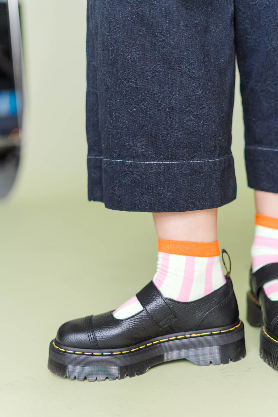 Detailed view of the cropped wide-leg hem showing the textured daisy pattern fabric and contrast stitching on the Nettle Studios Mid Easy Pant.