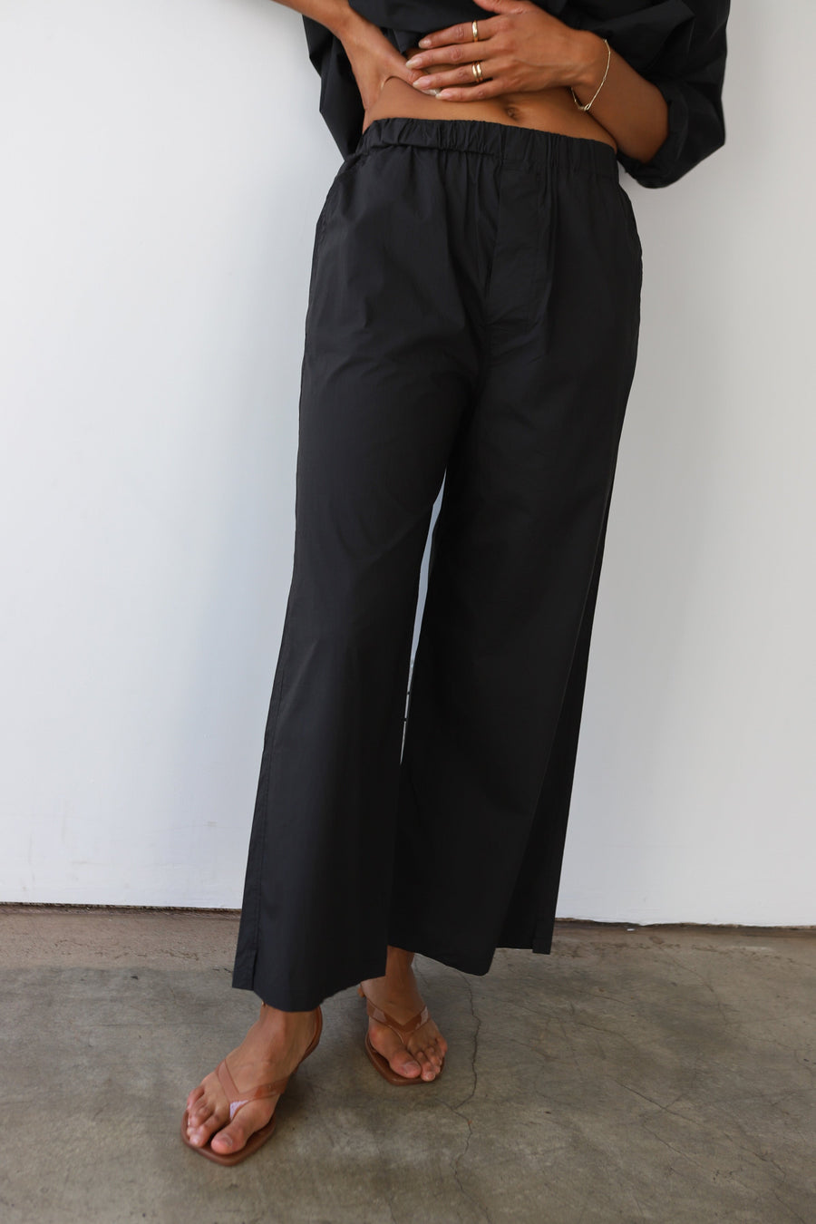 Black cotton poplin boxer pants with a classic elastic waistband and relaxed wide-leg fit. Casual lounge set styled on a model against a white backdrop by Be Idle.