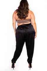 Rear view of a model showing the smooth back fit and elastic ankles of the black Sante Grace high-waisted silk jogger pants.