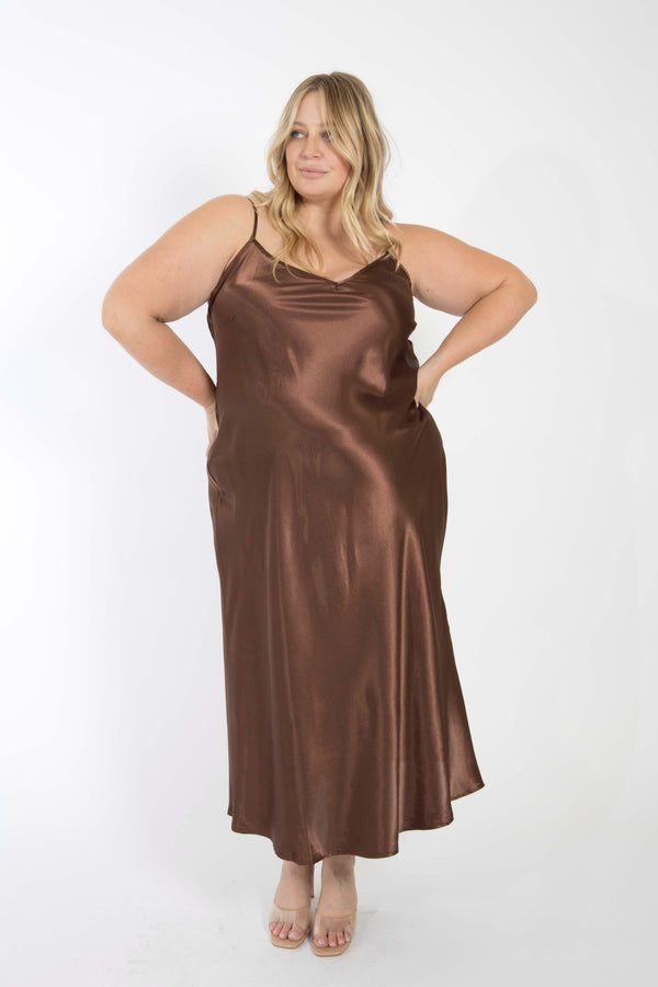 Front view of a plus-size model posing in the silky chocolate brown bamboo maxi slip dress .