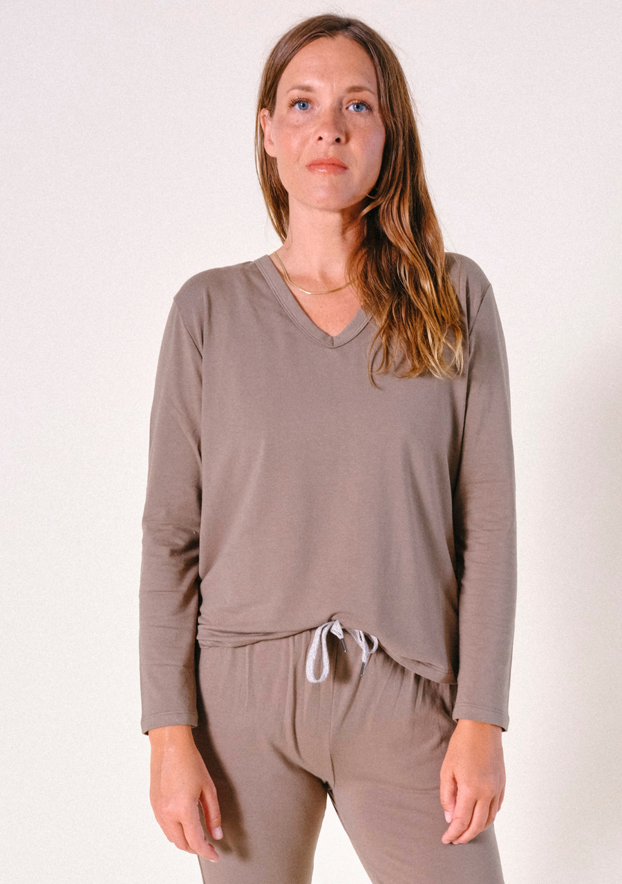 Front view portrait of a model wearing the olive long-sleeve V-neck Poplinen pajama shirt paired with matching lounge pants.