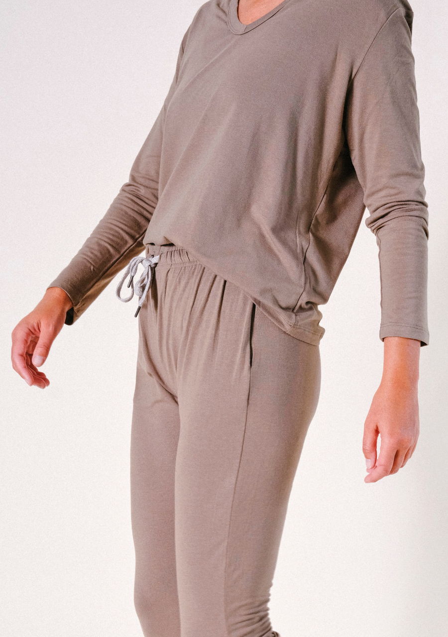 Side view of a model showcasing the relaxed silhouette and sleeve drape of the olive Poplinen pajama set.