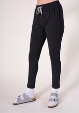 Side angle shot of the black tapered Poplinen Toni PJ Pant showcasing the cinched waistband and relaxed leg fit.