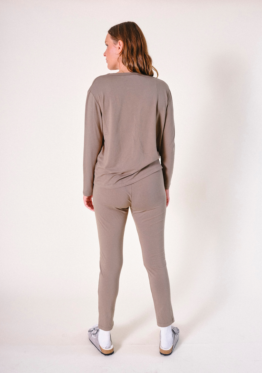 Full-length rear view of a model wearing the olive-brown Poplinen Toni PJ Pant paired with a matching long-sleeve pajama top.