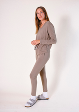 Full-body side profile shot of a model posing in the matching olive-brown Poplinen Toni pajama set.