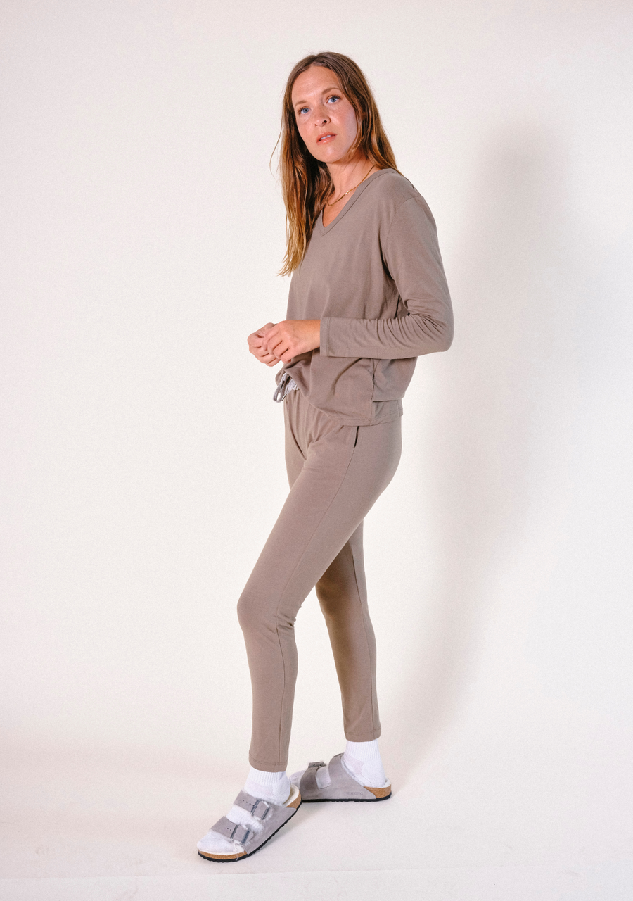 Full-body side profile shot of a model posing in the matching olive-brown Poplinen Toni pajama set.