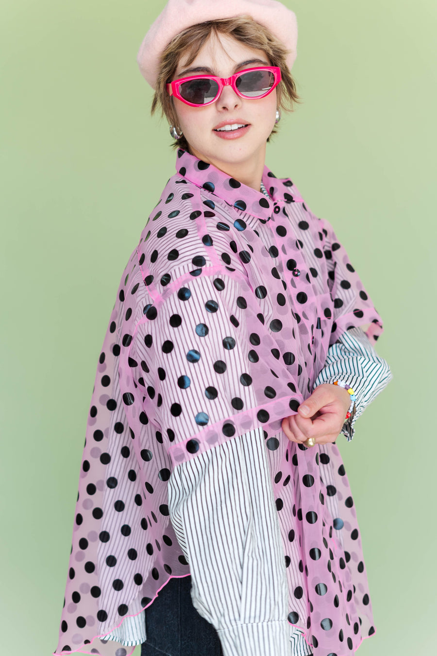 Side profile close-up showing the draped tulip sleeve detail on the sheer SK8R GRL polka dot top layered over a striped collared shirt.