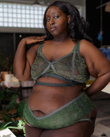 Front view of a plus-size Black model wearing succulent green lace cantiqLA Bandage Boyshorts with matching unlined bralette.