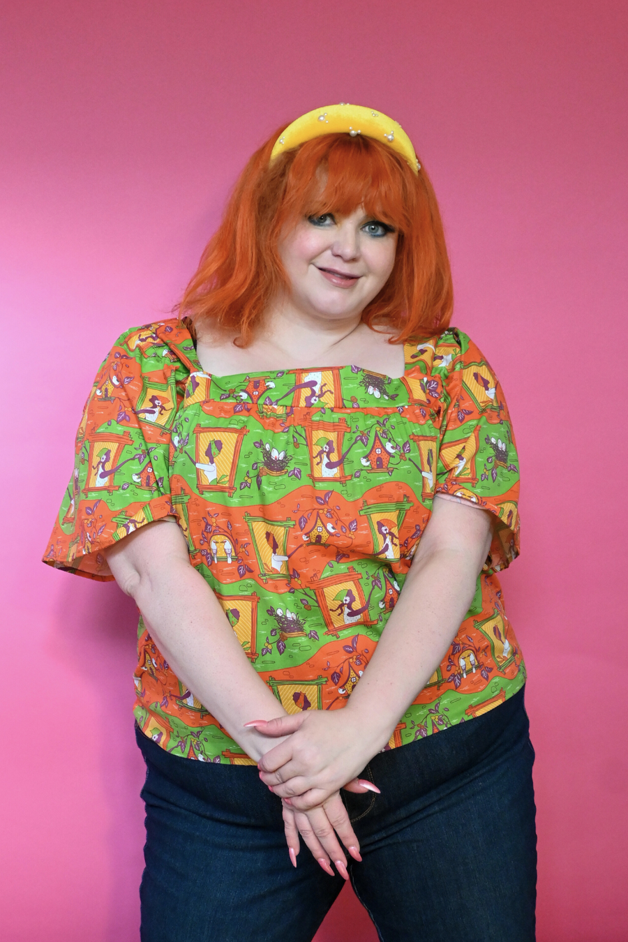 Studio portrait of a redhead model wearing the Blue Platypus Brownstone Betties Square Neck Peasant Top in Pumpkin & Olive cotton poplin.