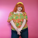 Three-quarter view of model in jeans and the Pumpkin & Olive Brownstone Betties Peasant Top