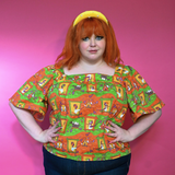 Front view showcasing the relaxed fit and square neckline of the size-inclusive Brownstone Betties Peasant Top in Pumpkin & Olive.