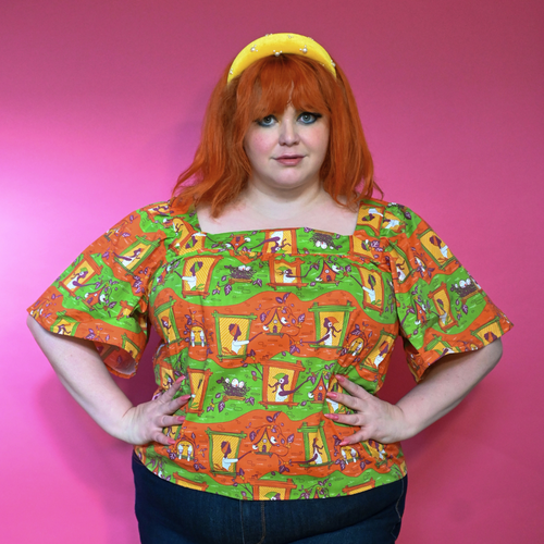 Front view showcasing the relaxed fit and square neckline of the size-inclusive Brownstone Betties Peasant Top in Pumpkin & Olive.