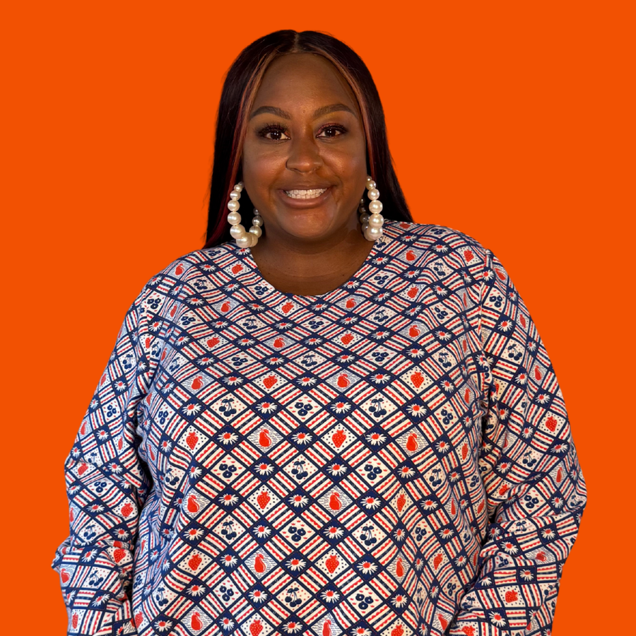 Plus-size model smiling while wearing the size-inclusive Blue Platypus Fruit Picnic Pullover in Blueberry.