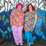 Two models posing together outdoors showing the vibrant floral and mushroom print on the Blue Platypus 3/4 sleeve top.