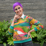Model with purple pixie hair wearing the Blue Platypus Landscape Pullover in Emerald layered over a white collared shirt.