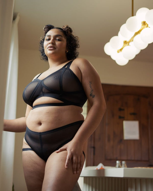 Model wearing the cantiqLA Mesh Vintage Soft Cup Bralette in black with matching briefs, size 1X