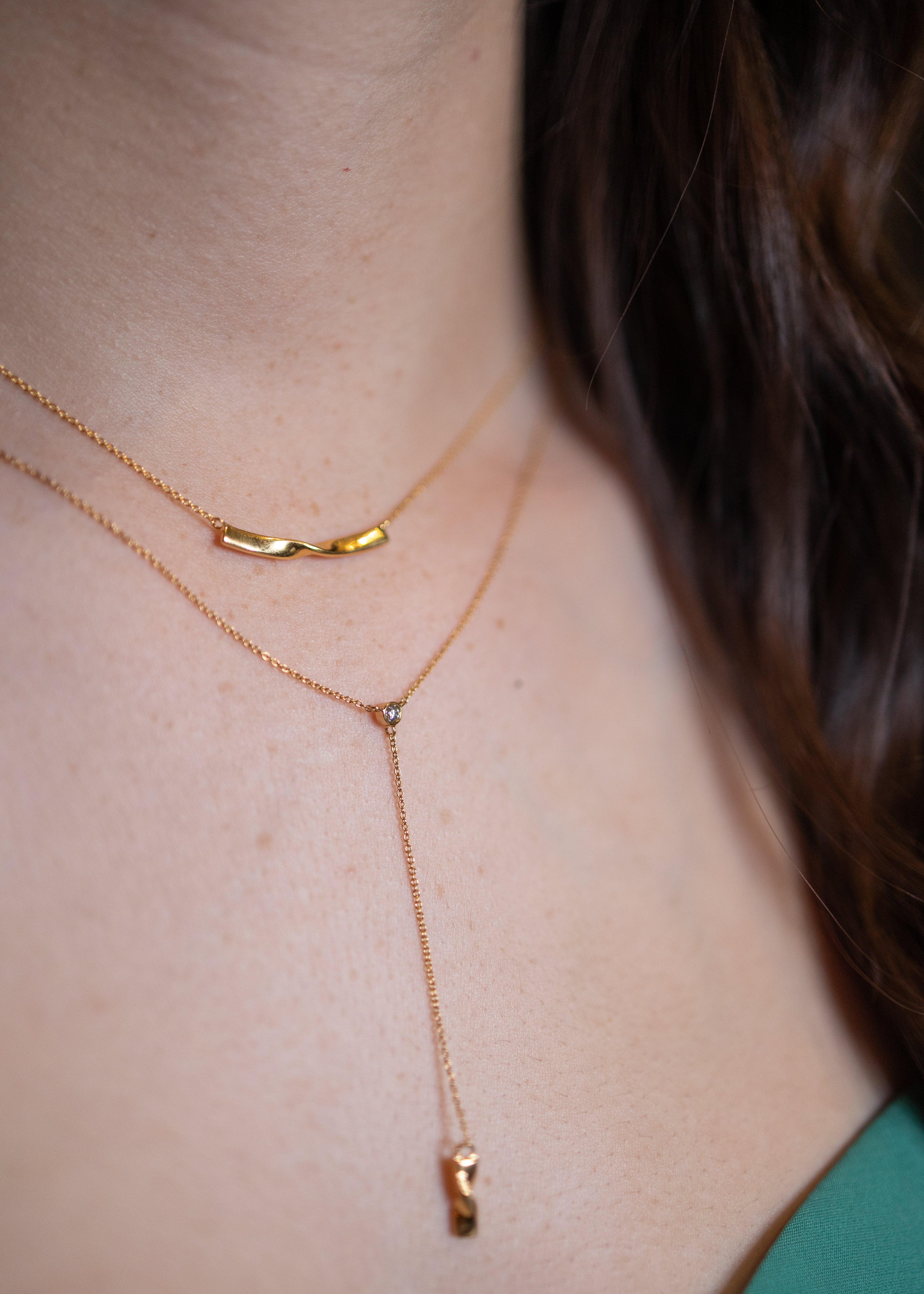 a gold Alsace necklace on a model layered with a gold twist necklace #color_gold