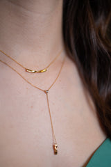 Chouette Designs a gold Alsace necklace on a model layered with a gold twist necklace
