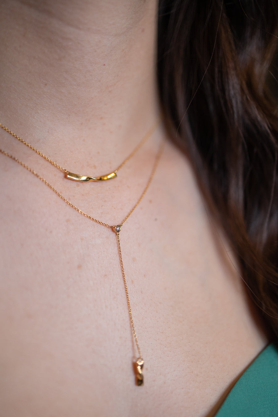 Chouette Designs a gold Alsace necklace on a model layered with a gold twist necklace