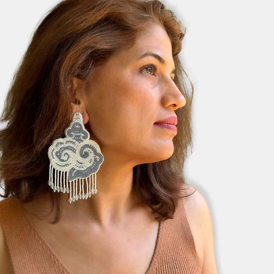 Side profile portrait of a woman wearing the oversized Fyoli Fyoli CLOUD hand-embroidered beaded statement earring.