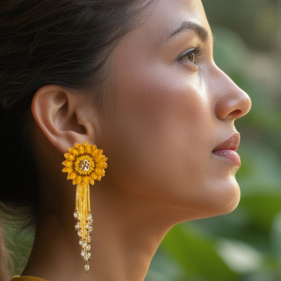 Close-up side profile of a model showcasing the intricate hand-embroidery of the Sunflower Yellow DAHLIA earring by Fyoli Fyoli. The 4-inch lightweight design features a prominent 3D flower and a cascading glass bead fringe.