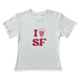 Front product flat lay of the off-white Fruit Face I Heart SF Baby Tee featuring strawberry cowboy graphic and red contrast stitching.