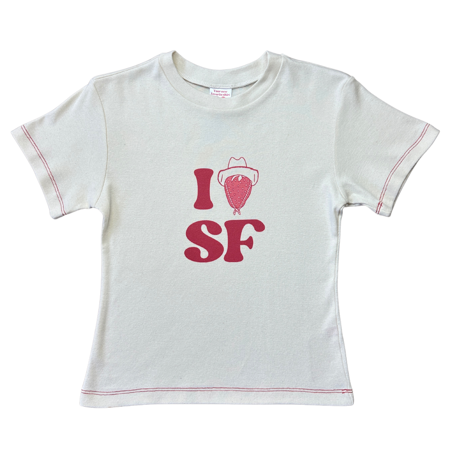 Front product flat lay of the off-white Fruit Face I Heart SF Baby Tee featuring strawberry cowboy graphic and red contrast stitching.