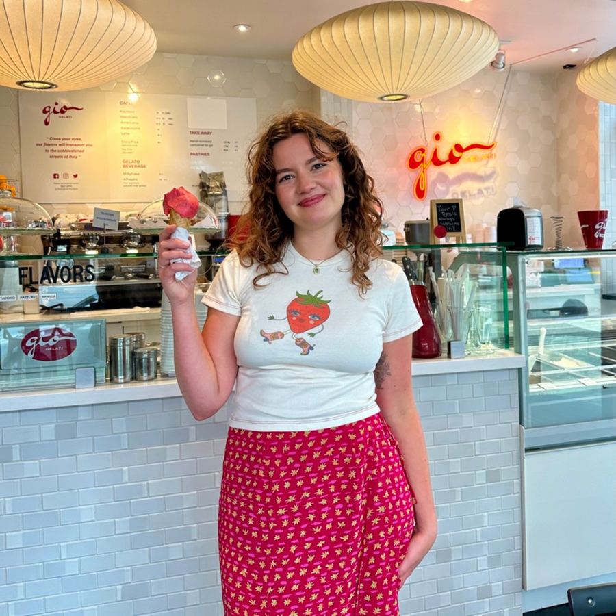 Model wearing Fruit Face Strawberry Cowgirl baby tee with strawberry graphic