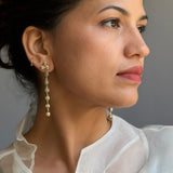 Close-up model portrait wearing the Fyoli Fyoli BEEJ gold seedpod dangle earrings.