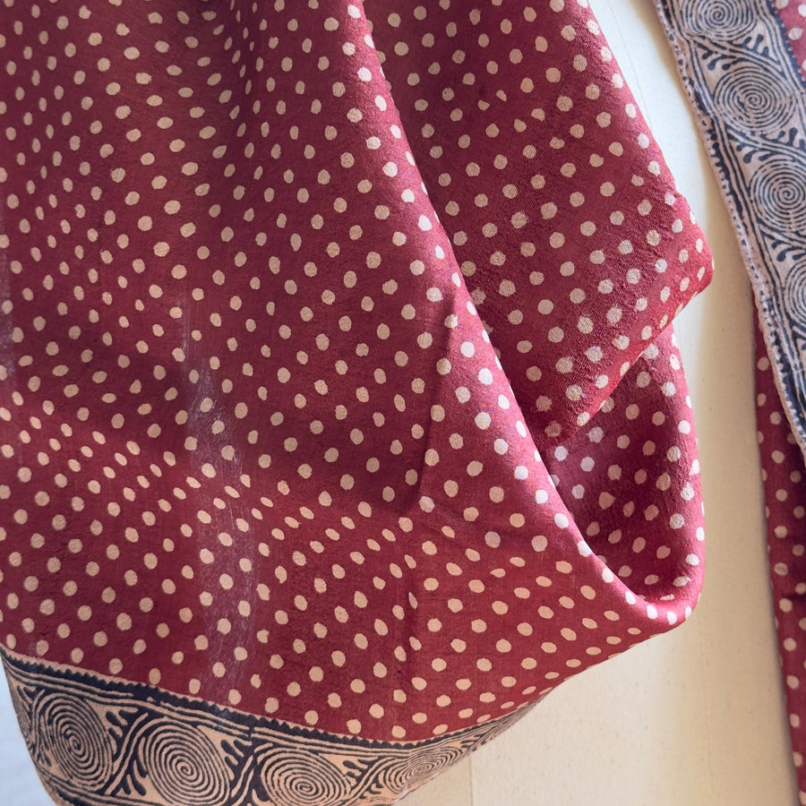Close-up texture detail of the handwoven Tassar silk fabric, polka dot print, and hand printed double spiral border.