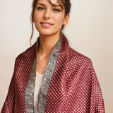 Model draped in the Fyoli Fyoli deep red BINDU Bagh Tassar Silk Stole showing the polka dot pattern and spiral border
