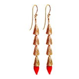 Straight-on view of the pair of gold-plated MIRCHI chili pod dangle earrings with red mouth-blown glass tips.