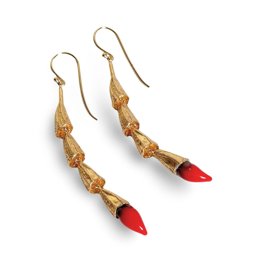 Studio view showing the articulated gold pod links and red glass chili details on the MIRCHI drop earrings.