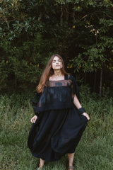 Model wearing the Hand-Painted Silk & Modal Bellows Skirt standing outdoors against a lush forest backdrop.