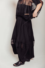 Side profile highlighting the architectural balloon silhouette and exposed tonal rolled serging on the Bellows Skirt.