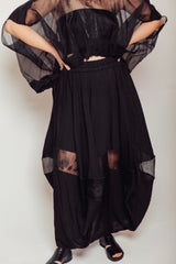 Front view of model wearing the black Hand-Painted Silk & Modal Bellows Skirt displaying the sheer dry-brushed organza window panel