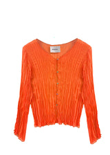 Studio flat lay product view of the Baacal Maya Hand-Pleated Cardigan in vibrant orange showing its V-neckline and Mother of Pearl button closure.