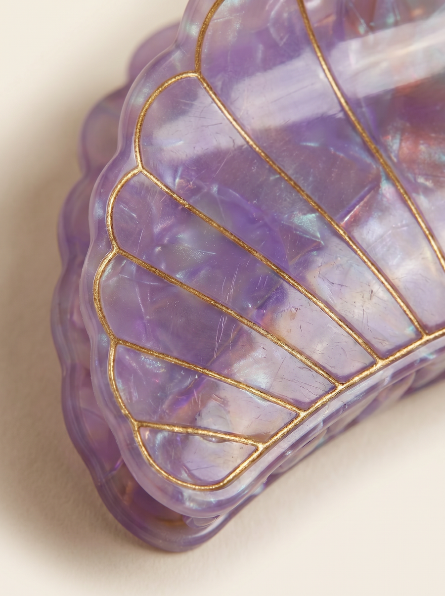 Flat lay view of the Village Thrive Shell Hair Clip in pink marbled recycled acetate, featuring decorative gold-lined shell ridge details.