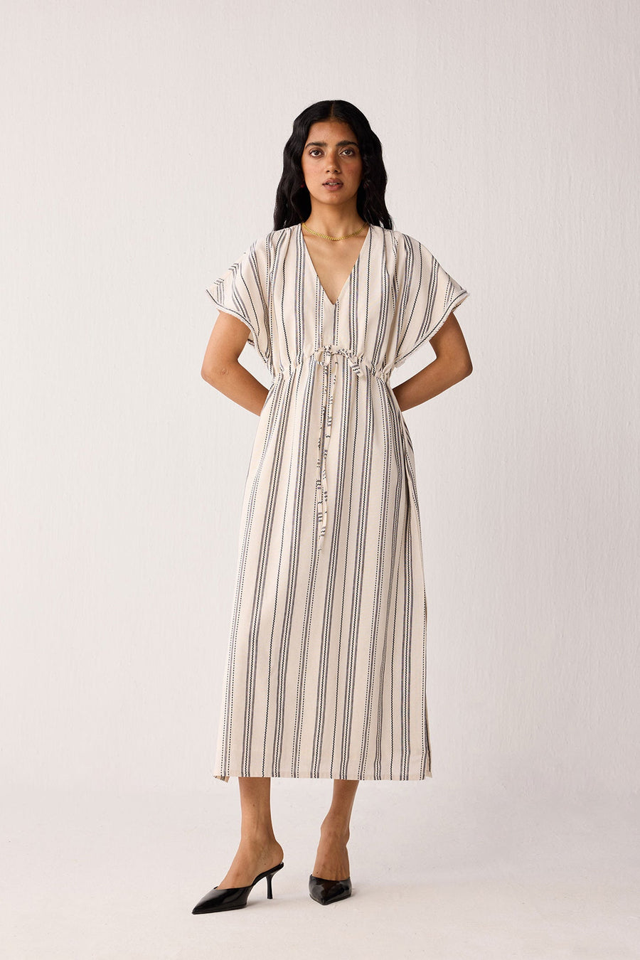 Woman wearing a striped dress on a white background