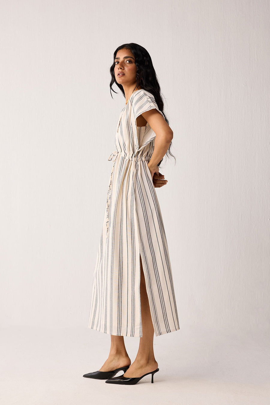 Woman wearing a striped dress on a plain background