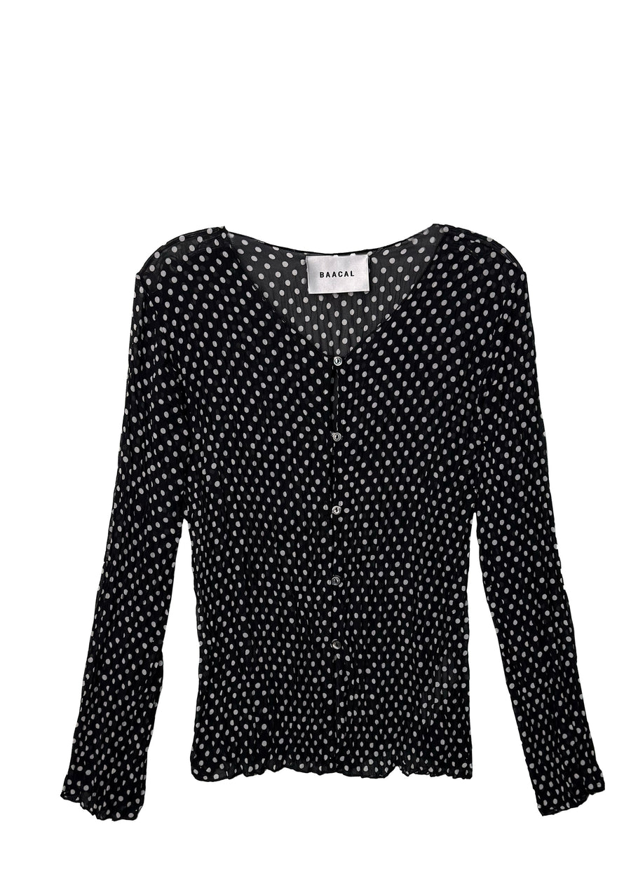 Studio flat lay product view of the Baacal Maya Hand-Pleated Cardigan in black and white polka dot print featuring a V-neckline and Mother of Pearl buttons.