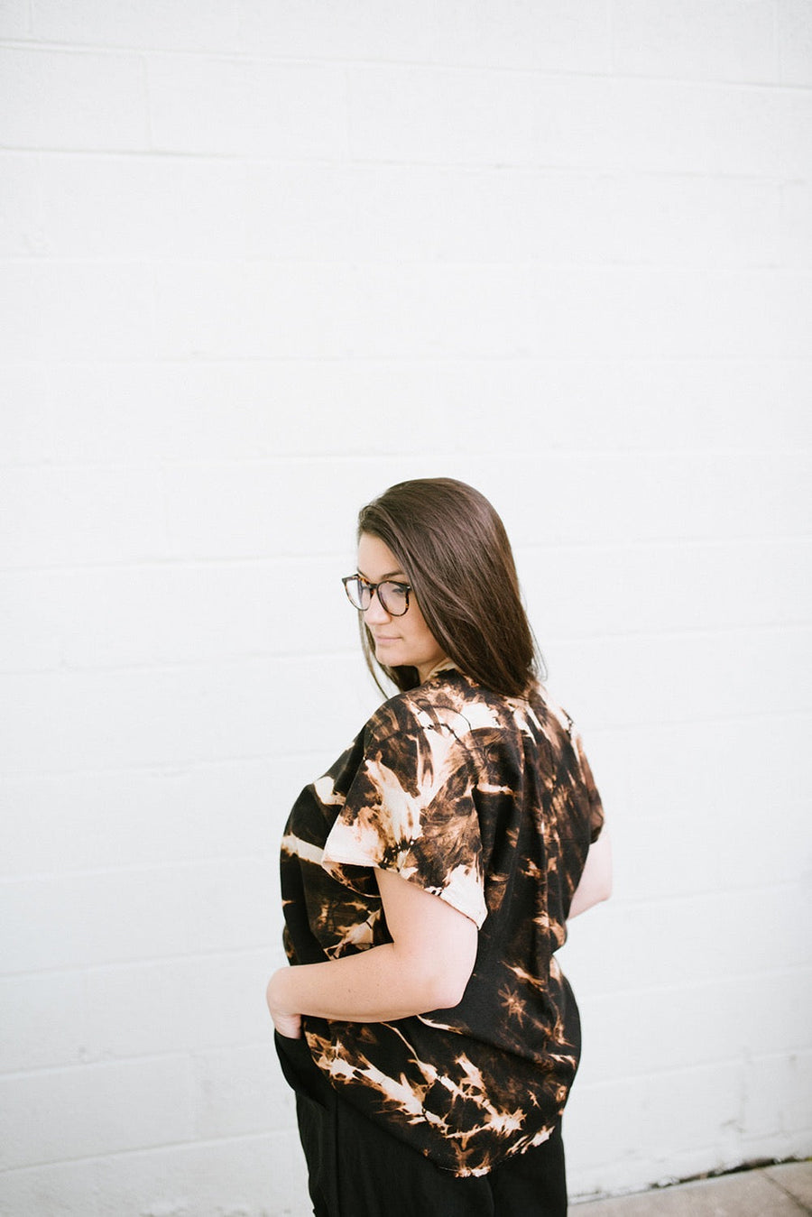 Rear quarter profile view highlighting the loose drape and tie-dye pattern on the Megan-Ilene Silk Market Top in black.