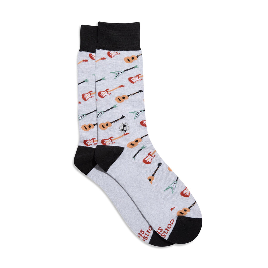 Flat lay product shot of Conscious Step Socks That Support Music displaying the grey guitar pattern and embroidered music note emblem on a plain background.