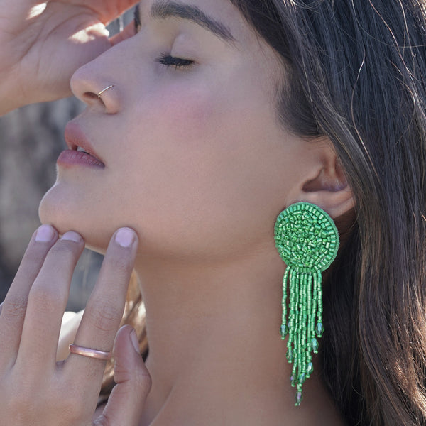 Profile view of a model wearing the 3.5-inch green TREE Moss Hand Embroidered Earrings.