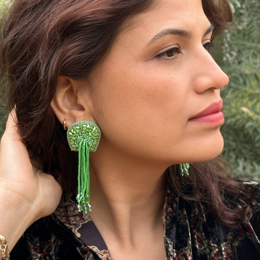 Side profile of a model wearing the green TORTULA Moss Hand Embroidered Earring, demonstrating how the lightweight statement ear ornament frames the face.