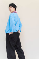 Rear view of model in the blue deadstock cotton jersey Nettle Studios Neptune Base Layer with black trousers.